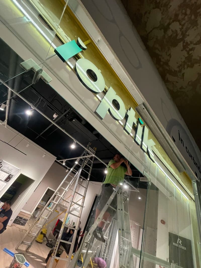 Litere volumetrice din plexiglas montate într-un spațiu interior, cu un design modern și iluminare LED. Semnul este parte a unui proiect de amenajare interioară.